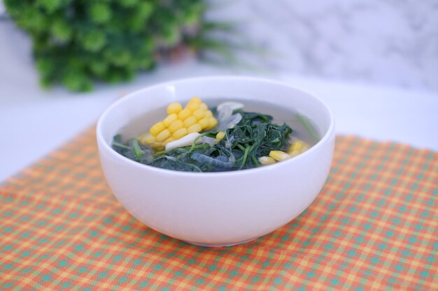 Foto sayur bening daun kelor jagung ou sopa clara de moringa oleifera com milho doce servida em uma tigela