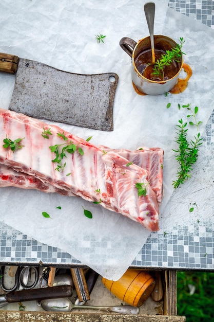 Sazonar costillas enteras con adobo y hierbas a la parrilla