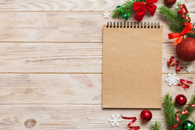 Foto scena de maqueta de tarjeta de felicitación en blanco de navidad diseño creativo hecho de ramas de árboles de navidad y nota de tarjeta de papel concepto de año nuevo de la naturaleza plana