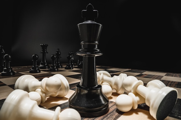 Schachfiguren auf hölzernem Schachbrettmakrofoto