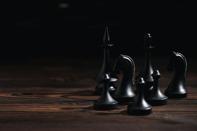 Schachfiguren auf Holzoberfläche isoliert auf schwarz