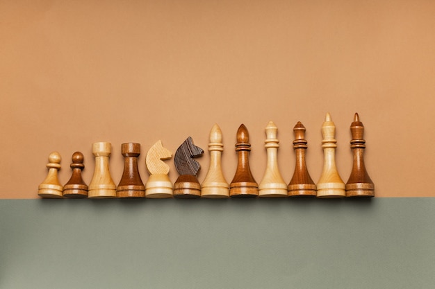 Schachfiguren in einer Reihe auf einer Draufsicht des flachen Hintergrunds