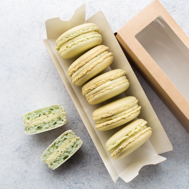 Schachtel mit Pistazien leckeren Macarons auf weißem Hintergrund