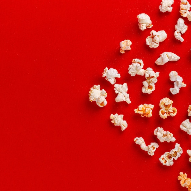 Schachtel mit Popcorn auf rotem Hintergrund in Nahaufnahme