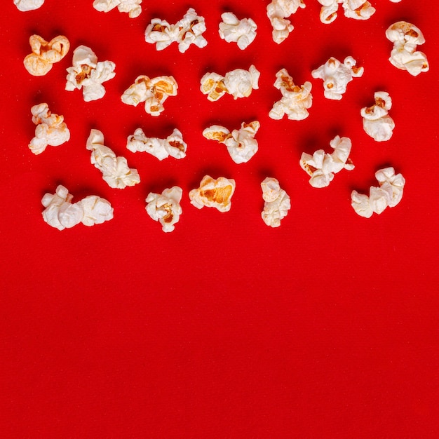 Schachtel mit Popcorn auf rotem Hintergrund in Nahaufnahme