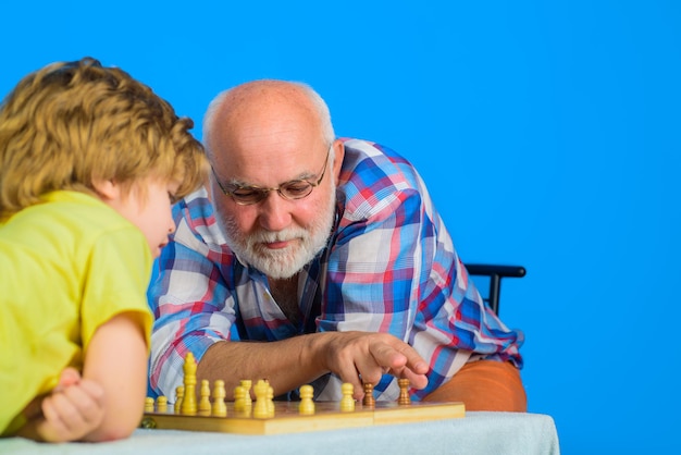 Schachwettbewerb Großvater und Enkel spielen Schach kleiner Junge spielt Schach mit Opa
