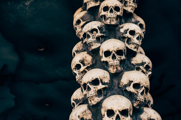 Schädel-Halloween-Hintergrund Viele Leute-Schädel stehen übereinander. Mystisches gruseliges Konzept. Abstraktes okkultes Denkmal des Albtraums.