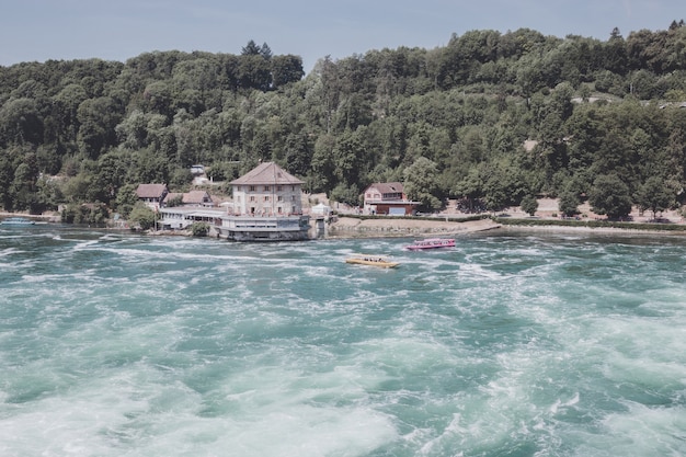 Schaffhausen, Suiza - 20 de junio de 2017: Ver las cataratas del Rin es la cascada más grande de Europa y la gente en barco a su alrededor. Día de verano con cielo azul