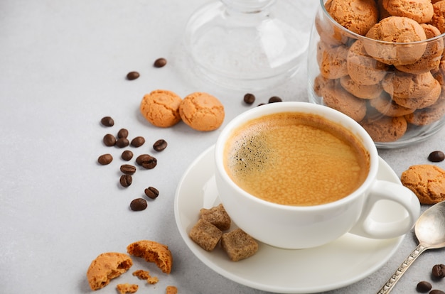 Schale frischer Kaffee mit Amaretti-Plätzchen auf grauem Beton