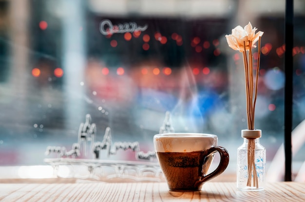 Schale heißer Espresso auf Holztisch in der Kaffeestube mit Kopienraum.