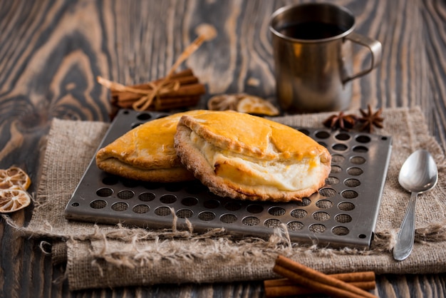 Schale heißer Tee und süße Brötchen auf Holztisch. Draufsicht