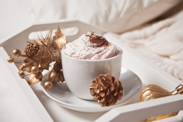 Schale Kakao auf dem weißen Behälter auf dem frühen Wintermorgen des Betts
