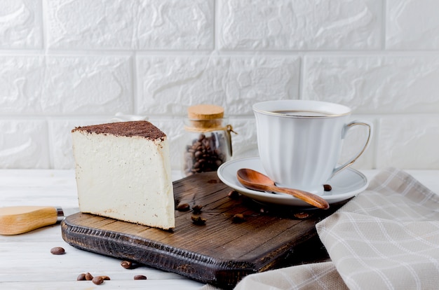 Schale schwarzer Kaffee mit einem Stück Weichkäse im gemahlenen Kaffee