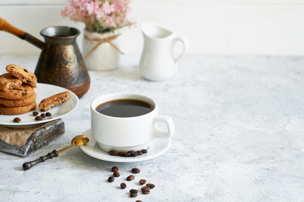 Schale schwarzer starker Kaffee mit Kaffeebohnen und Plätzchen