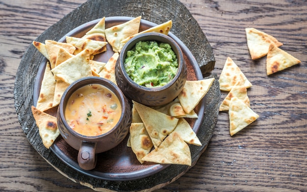 Schalen mit Guacamole und Queso mit Tortillachips