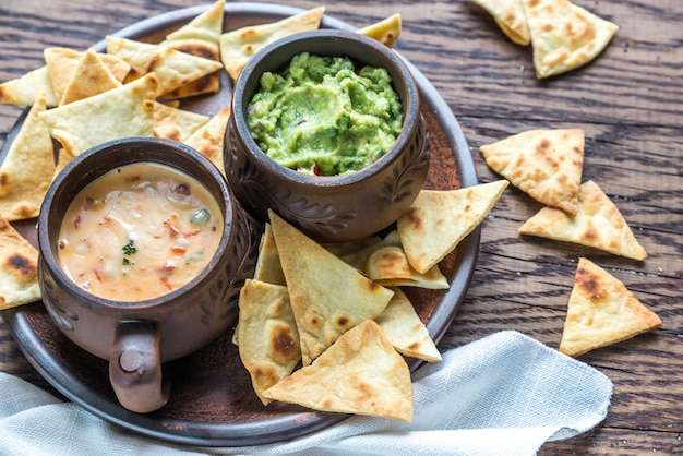 Schalen mit Guacamole und Queso mit Tortillachips