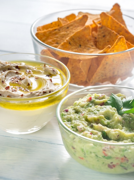 Schalen mit Hummus und Guacamole mit Tortillachips