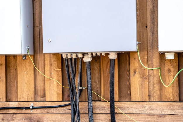 Schalttafeln und mit ihnen verbundene elektrische Kabel an der Wand des Hauses Stromversorgung des Hausbaus