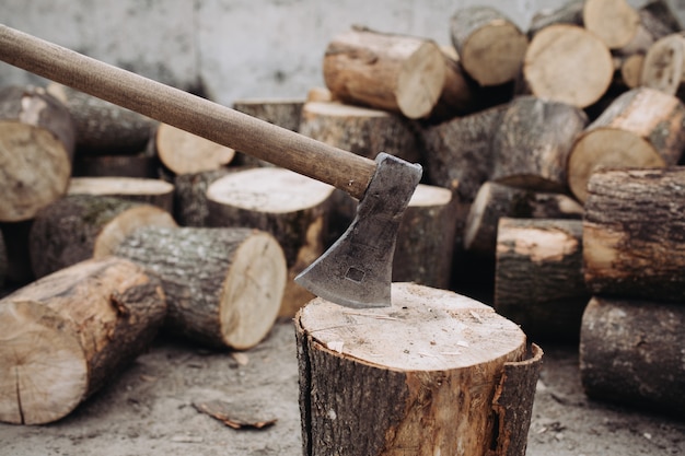 Scharfe Axt steckte in einem Baumstumpf zwischen geschnittenem Holz