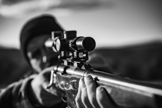 Scharfschützen-Karabiner beim Outdoor-Jagdjäger mit dem Zielgewehr im Waldjäger mit Schrotflinte gu hautnah