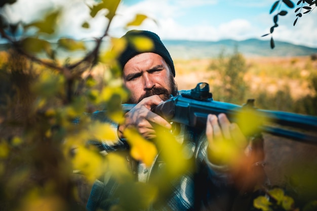 Scharfschützenkarabiner bei der Outdoor-Jagd hautnah. Mann, der Schrotflinte hält. Jäger mit Schrotflinte auf der Jagd. Hirschjagd.