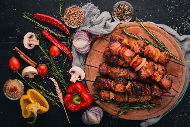 Schaschlik am Spieß mit Zwiebeln auf dem schwarzen Holztisch