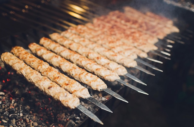 Foto schaschlik schweine- oder lammfleischstücke werden auf einem holzkohlegrill gebraten