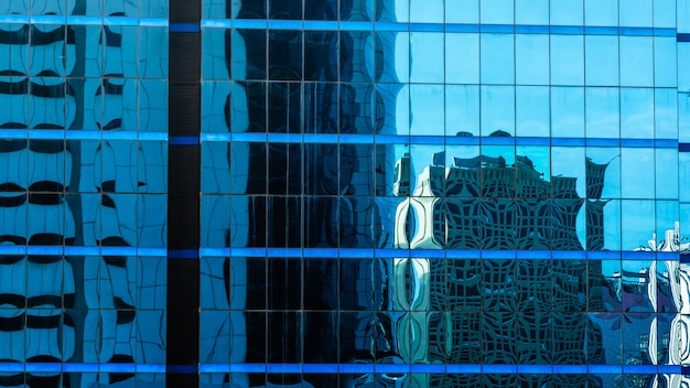 Schatten des blauen Himmels und des Turms reflektierten sich im Glasgebäude