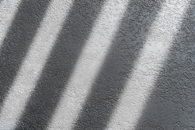 Schatten und Licht durch Jalousienfenster an gefliester Wand