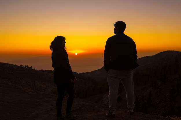 Schattenbild der jungen Leute bei Sonnenuntergang auf dem Berg Teide auf der Insel Teneriffa