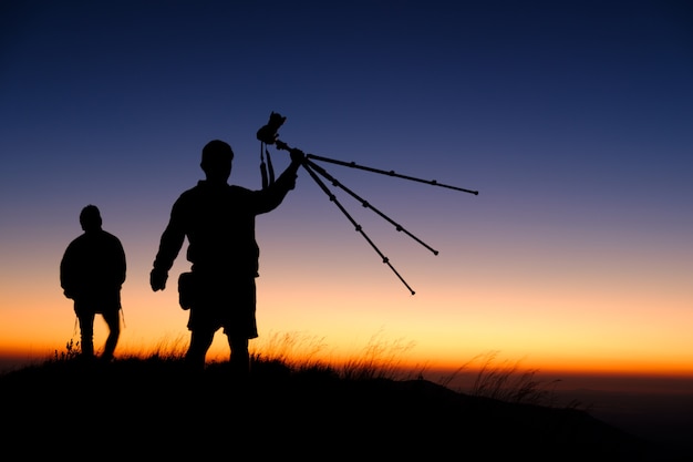 Schattenbild des Fotografshowstativs auf Berg bei Sonnenunterganghintergrund, Thailand