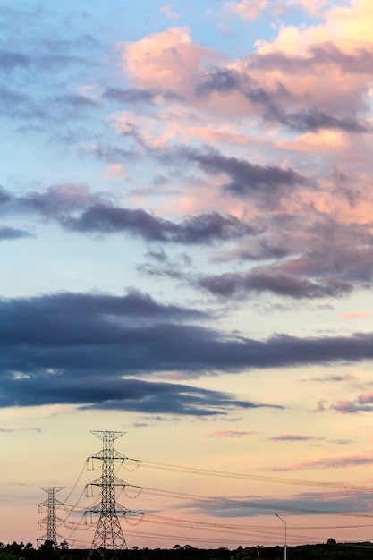 Foto schattenbild des hochspannungspfostens und des wolkenhintergrundes.