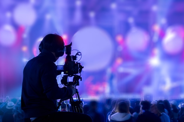 Schattenbild des Mannes, der Ereignis auf Stadium mit Videokamera bedeckt