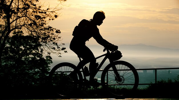 Schattenbild des Radfahrers auf Mountainbiker bei Sonnenuntergang