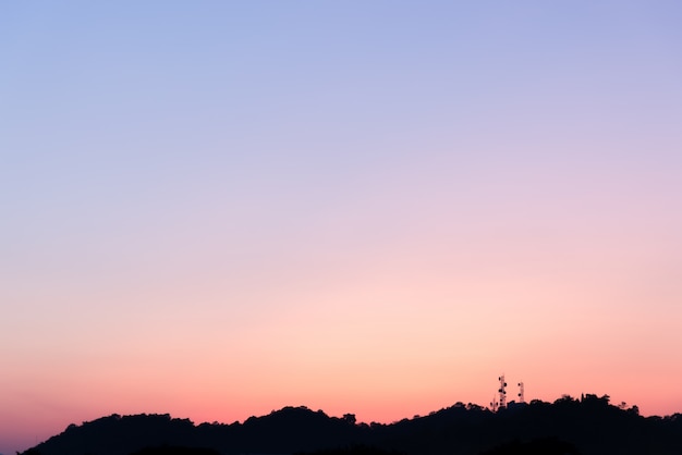 Schattenbild des Telekommunikationsturms auf dem Berg mit buntem Himmel.