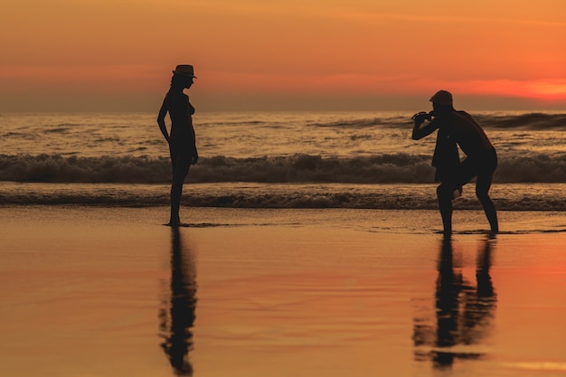 Schattenbild des Touristen am Sonnenuntergangstrand in Phuket Thailand