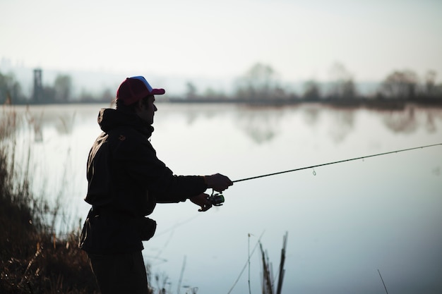 Foto schattenbild eines fischerfischens auf see