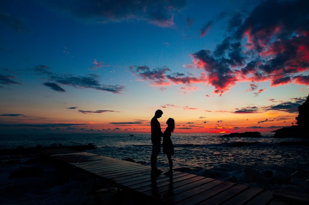 Schattenbild eines frisch verheirateten Paares am Meer bei Sonnenunterganghochzeit in