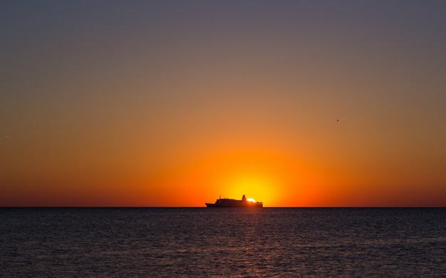 Schattenbild eines Touristenschiffs bei Sonnenuntergang