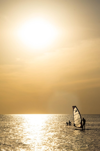 Schattenbild eines Windsurfers auf Wellensonnenuntergang