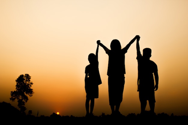 Foto schattenbild von kindern mit schönem sonnenunterganghintergrund.