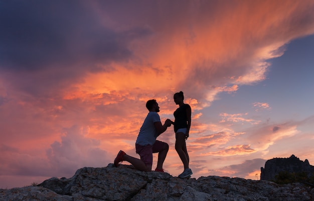 Schattenbilder eines Mannes, der seiner Freundin Heiratsantrag macht