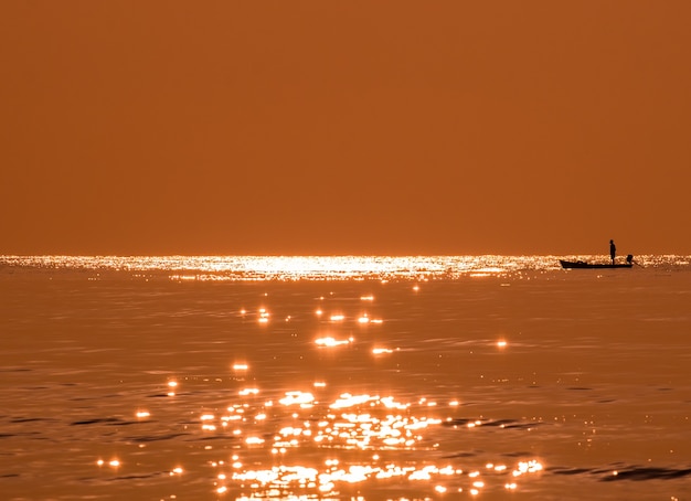 Schattenbildfischer, der goldenes Meer fischt, schöner Glanz natürlich morgens