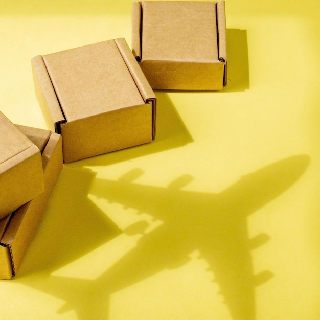 Schattenflugzeug und Stapel von Kartons Konzept von Luftfracht und Paketen Luftpost Schnelle Lieferung von Waren und Produkten Frachtflugzeug Logistikverbindung zu schwer erreichbaren Orten Bannerkopierraum