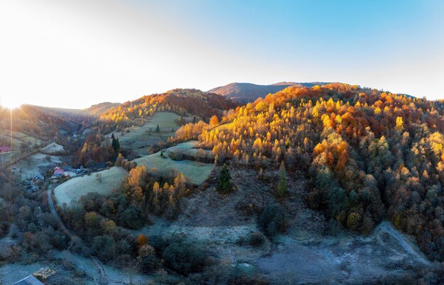 Schattiges Bergtal mit Häusern und Wäldern bei Sonnenuntergang