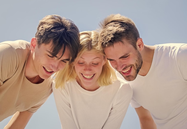 Schauen Sie hier Sorglose Jugend hängt zusammen ab Sehen Sie etwas Entzückendes Fröhlichkeit Gruppe Menschen aufgeregt nach unten schauen Frauen und Männer glücklicher Himmelshintergrund Fröhlichkeit in Einheit Aufgeschlossen für Glück