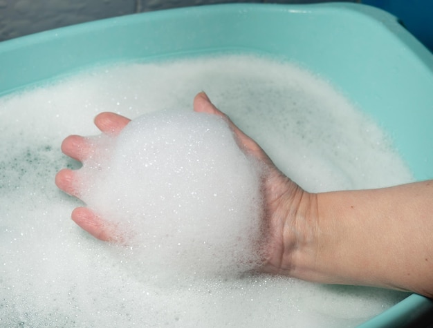 Schaum in der Hand Geschirrspülen Waschbecken