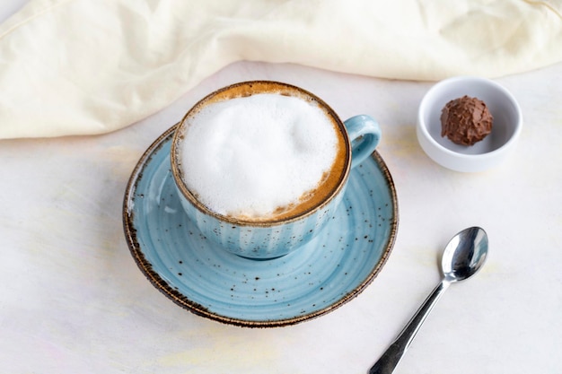 Schaumcappuccino auf einem weißen hölzernen Hintergrund