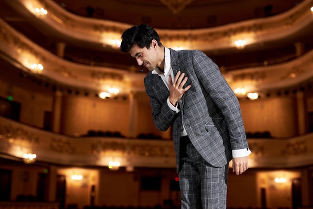 Foto schauspieler oder opernsänger verbeugen sich nach der aufführung und drücken ihre dankbarkeit aus, die eine angenehme und nette geschichte darstellt