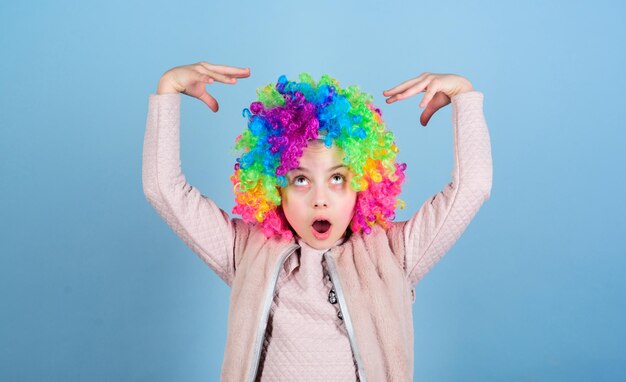 Schauspielschule für kinder entwickeln sie schauspielerisches talent zur karriere künstlerisches kind, das schauspielerische fähigkeiten übt kid bunte lockige perücke kunsthaar clown-stil blauer hintergrund konzept der zirkusschule